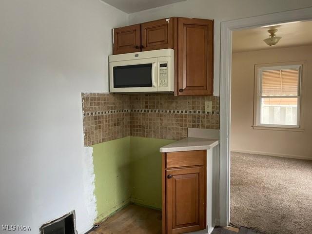 1145 Arnold Ave, Akron, OH 44305 - kitchen with baseboards, brown cabinetry, white microwave, and light countertops
