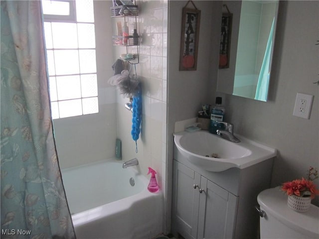 full bathroom featuring shower / bathtub combination with curtain, toilet, and vanity