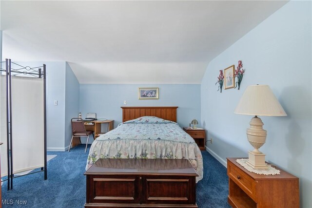 bedroom featuring baseboards, dark colored carpet, and lofted ceiling