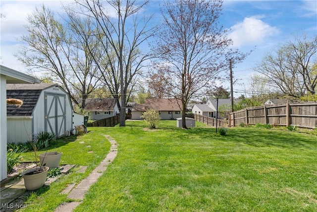 view of yard featuring an outbuilding, a storage shed, and fence