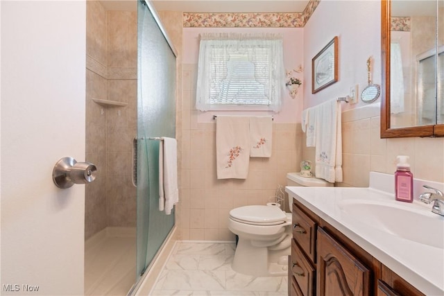 full bath featuring a shower stall, marble finish floor, tile walls, toilet, and vanity
