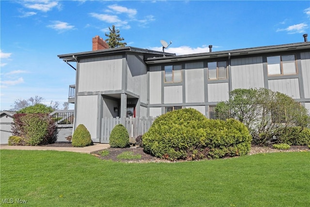 exterior space featuring a lawn, stairway, and a chimney