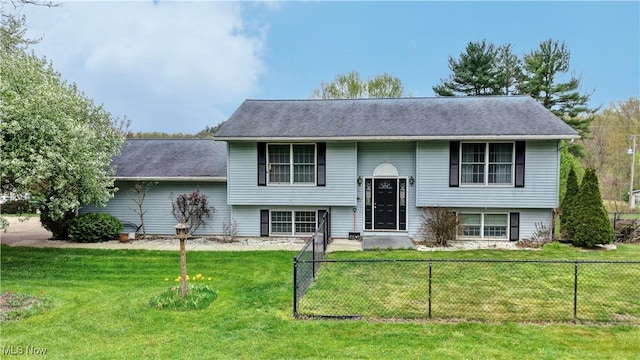 bi-level home with fence and a front lawn