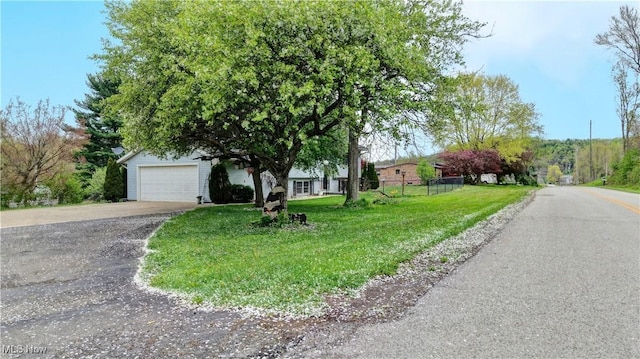 view of front of property with fence, a front yard, and concrete driveway