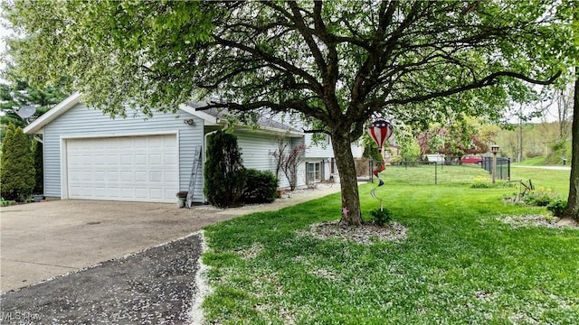 exterior space with a lawn, fence, and a detached garage