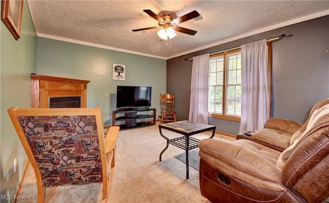 carpeted living area with a textured ceiling, a glass covered fireplace, a ceiling fan, and crown molding