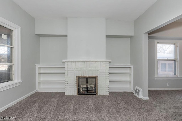 unfurnished living room featuring a brick fireplace, visible vents, carpet floors, and baseboards