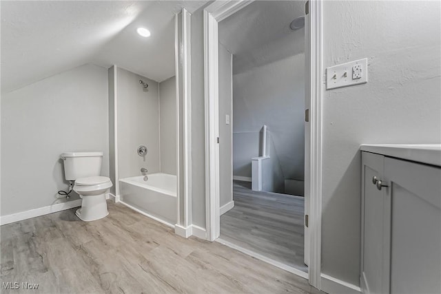 full bathroom featuring wood finished floors, bathing tub / shower combination, vaulted ceiling, toilet, and baseboards
