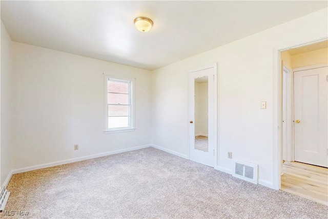 empty room with baseboards, visible vents, and carpet floors