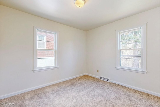 carpeted spare room with baseboards and visible vents