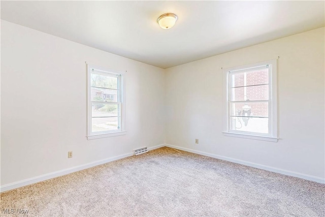 carpeted empty room with baseboards and visible vents