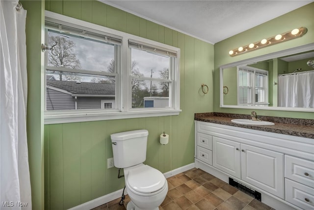 bathroom featuring toilet, baseboards, and vanity