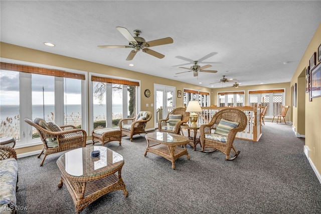 carpeted living room with recessed lighting, baseboards, a ceiling fan, and a water view