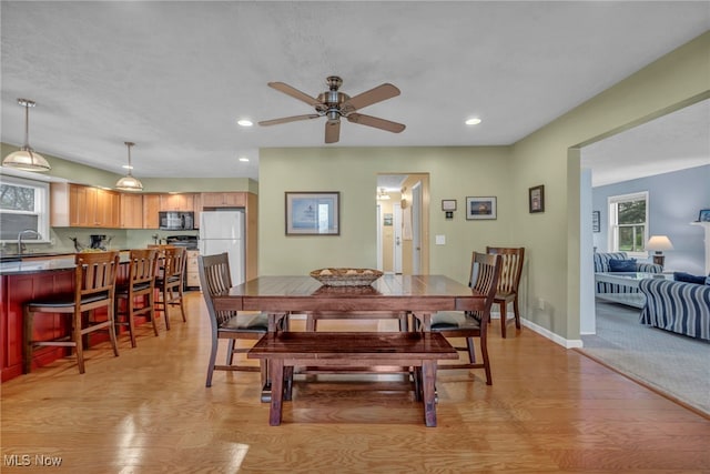 dining room with light wood-style floors, baseboards, a ceiling fan, and recessed lighting