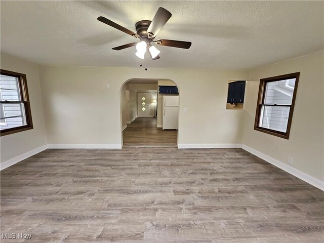 1893 Ridge Rd, Hinckley, OH 44233 - unfurnished room featuring arched walkways, a healthy amount of sunlight, wood finished floors, and ceiling fan