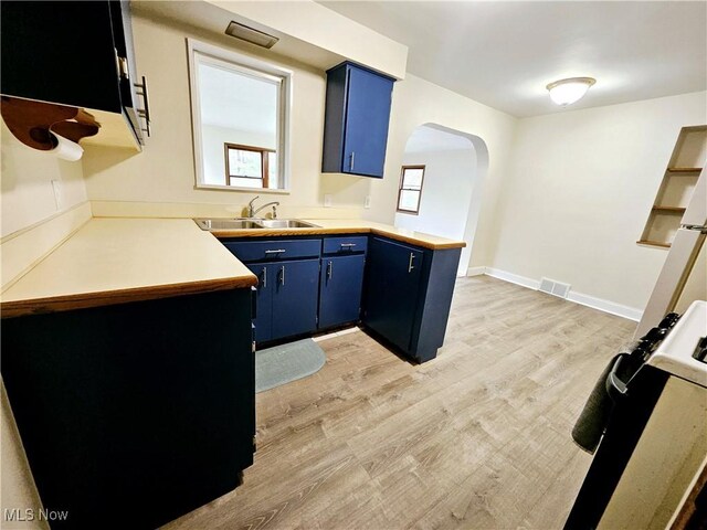 1893 Ridge Rd, Hinckley, OH 44233 - kitchen featuring a sink, visible vents, a peninsula, arched walkways, and blue cabinets