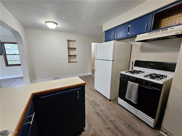 1893 Ridge Rd, Hinckley, OH 44233 - kitchen with blue cabinetry, freestanding refrigerator, under cabinet range hood, visible vents, and range with gas stovetop
