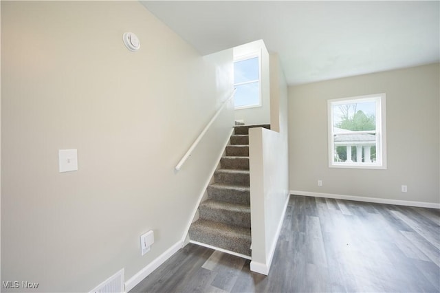 stairway with wood finished floors and baseboards