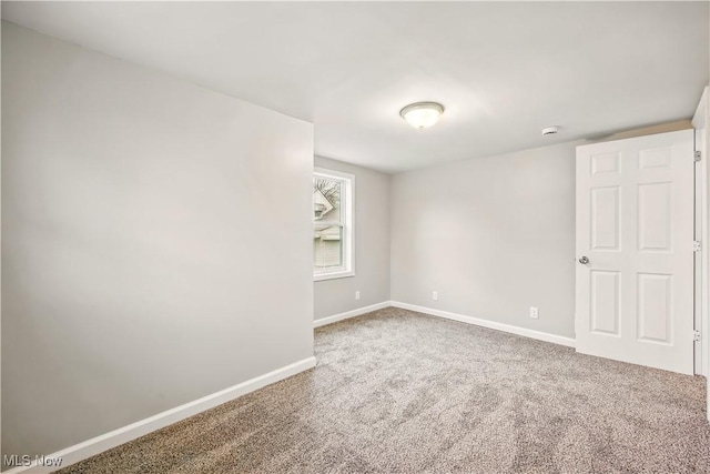 carpeted spare room featuring baseboards