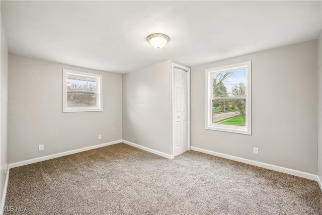 unfurnished bedroom featuring a closet, carpet flooring, and baseboards