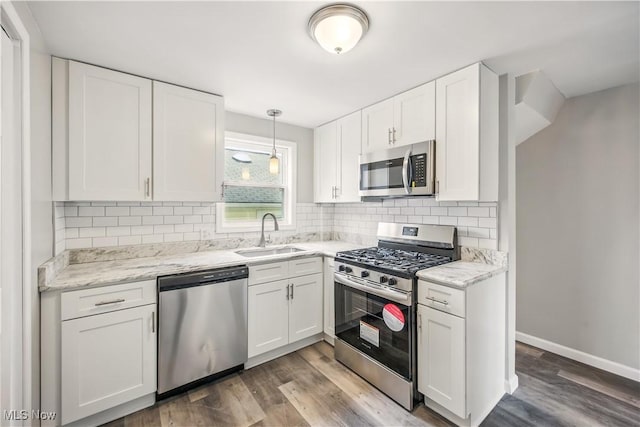 kitchen featuring backsplash, a sink, white cabinets, and appliances with stainless steel finishes