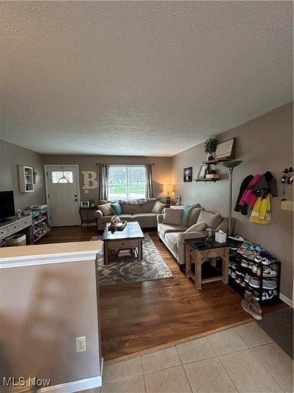 living area featuring light tile patterned flooring and a textured ceiling