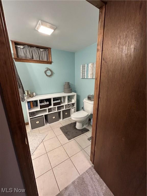 bathroom with toilet and tile patterned flooring
