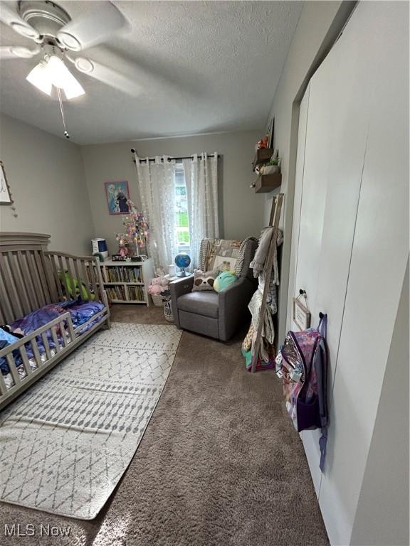 carpeted bedroom with a textured ceiling and ceiling fan