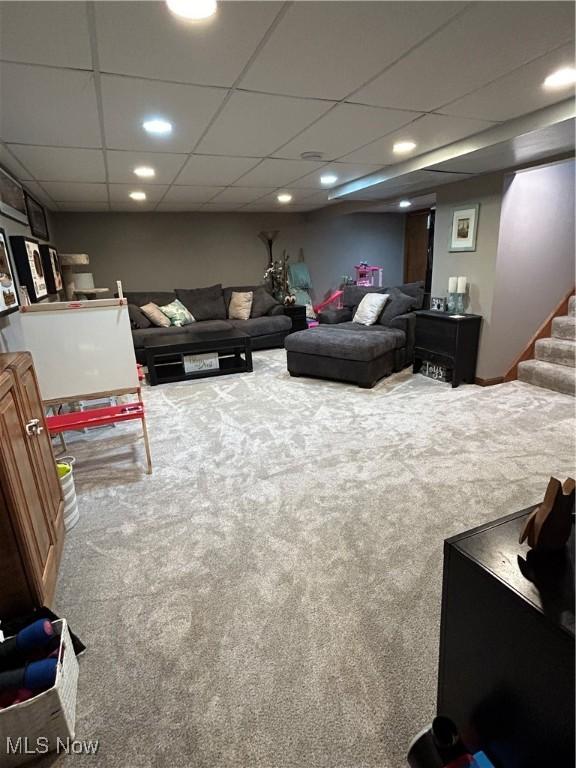 carpeted living area with recessed lighting, a paneled ceiling, and stairway