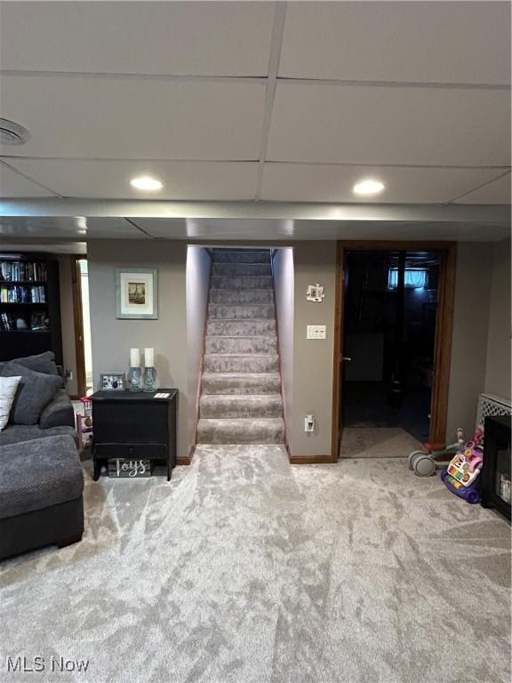 carpeted living room featuring stairway and a paneled ceiling