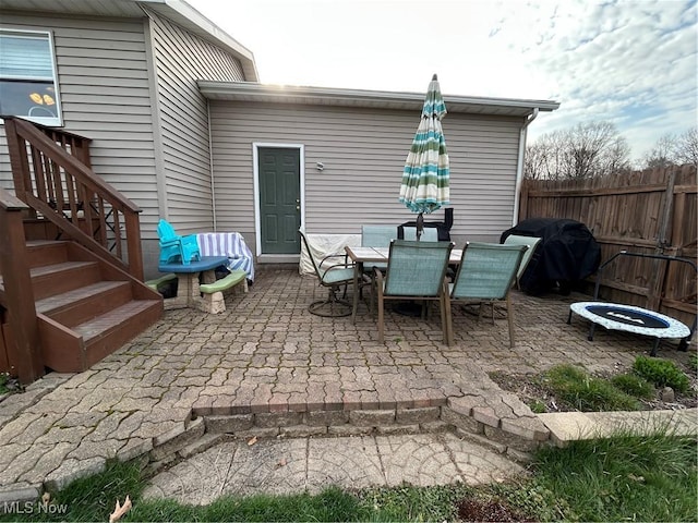 view of patio featuring a fire pit, fence, area for grilling, and outdoor dining area