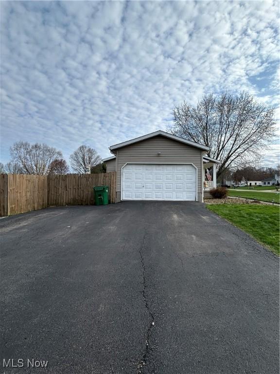 garage with fence and driveway