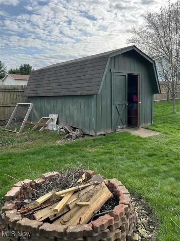 view of shed featuring a fire pit and fence