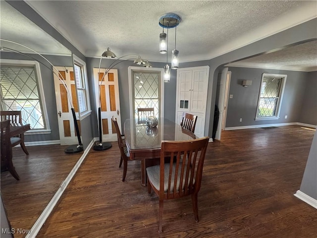 dining area featuring baseboards, arched walkways, a textured ceiling, and dark wood finished floors