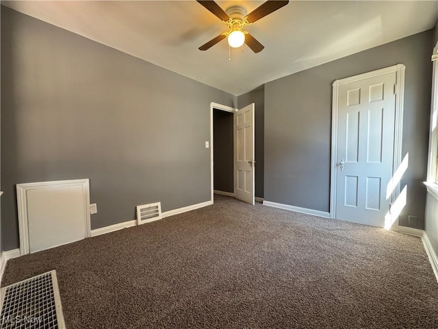 unfurnished bedroom with baseboards, visible vents, a ceiling fan, and carpet