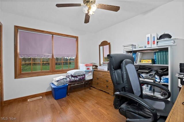 home office featuring wood finished floors, visible vents, ceiling fan, and baseboards