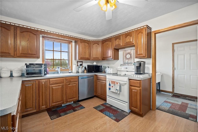 kitchen featuring stainless steel dishwasher, a sink, black microwave, electric stove, and brown cabinetry