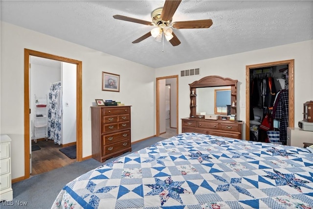 bedroom with a spacious closet, carpet floors, a closet, visible vents, and a textured ceiling