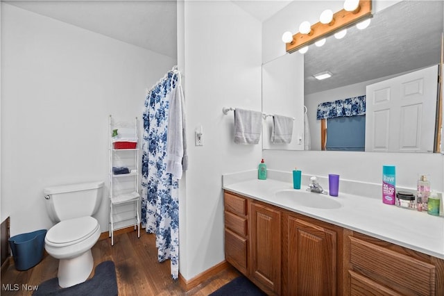 full bathroom with a shower with curtain, baseboards, toilet, wood finished floors, and vanity