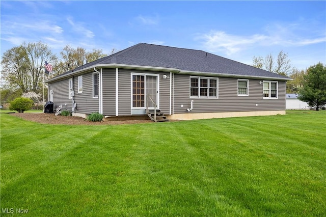 rear view of house featuring a yard and entry steps