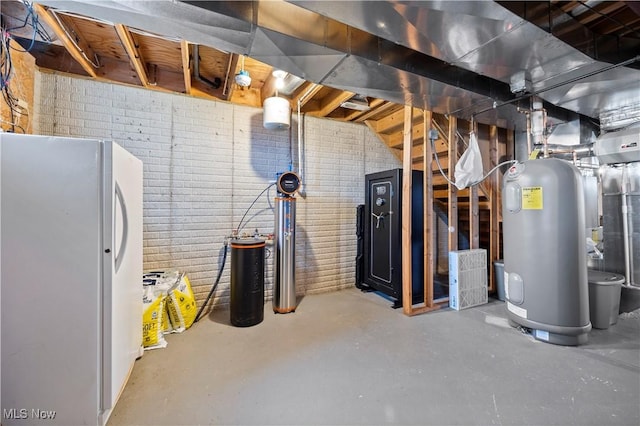 unfinished basement with electric water heater and freestanding refrigerator