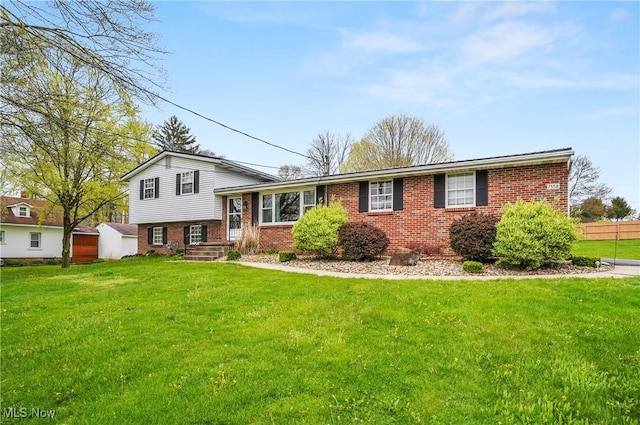 split level home with a front yard and brick siding