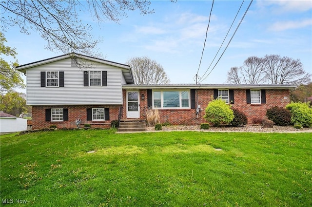 tri-level home with a front yard and brick siding