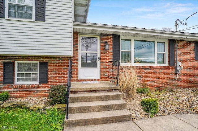doorway to property with brick siding