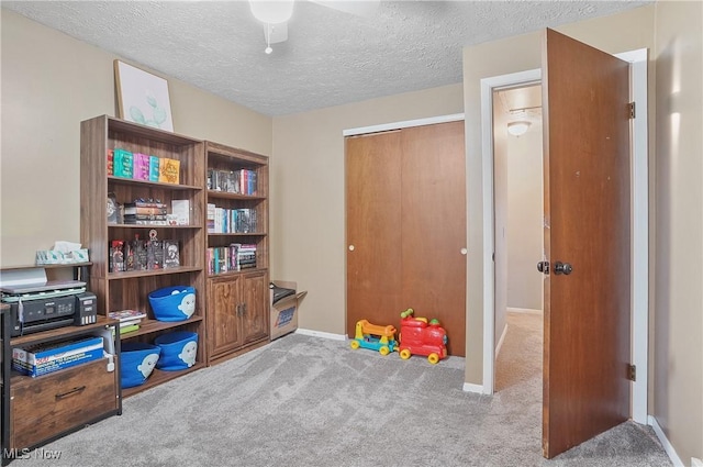playroom featuring a textured ceiling, baseboards, and carpet floors