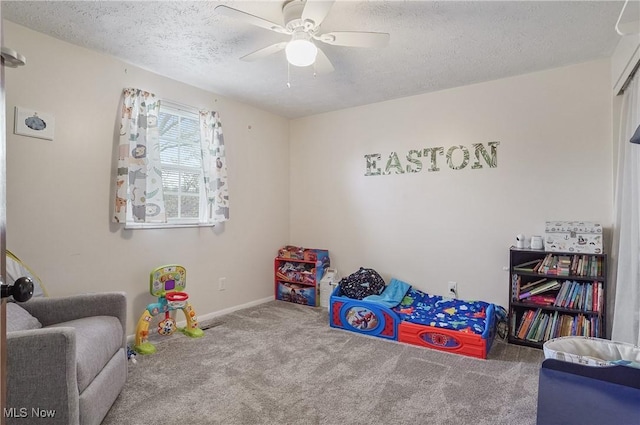 rec room with a textured ceiling, baseboards, a ceiling fan, and carpet floors