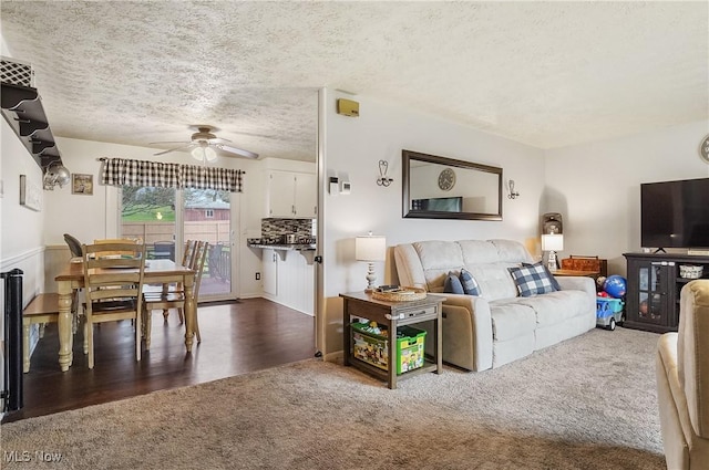 living room featuring a textured ceiling, a ceiling fan, and carpet flooring