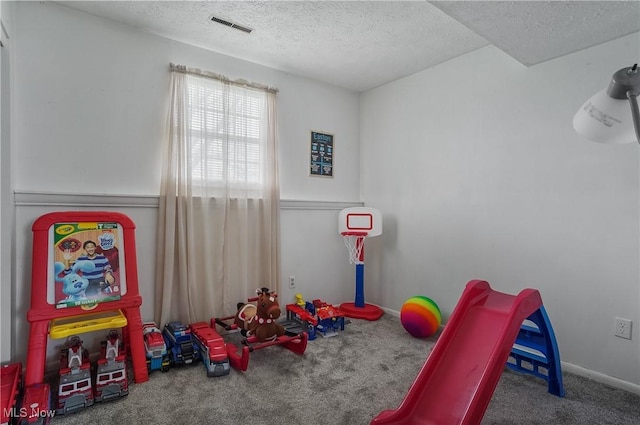 rec room with carpet, visible vents, baseboards, and a textured ceiling