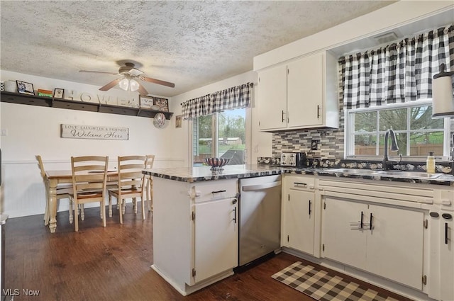 kitchen featuring dark wood finished floors, ceiling fan, dishwasher, a sink, and a peninsula