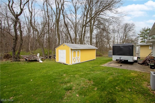 view of yard featuring a storage unit, cooling unit, and an outbuilding